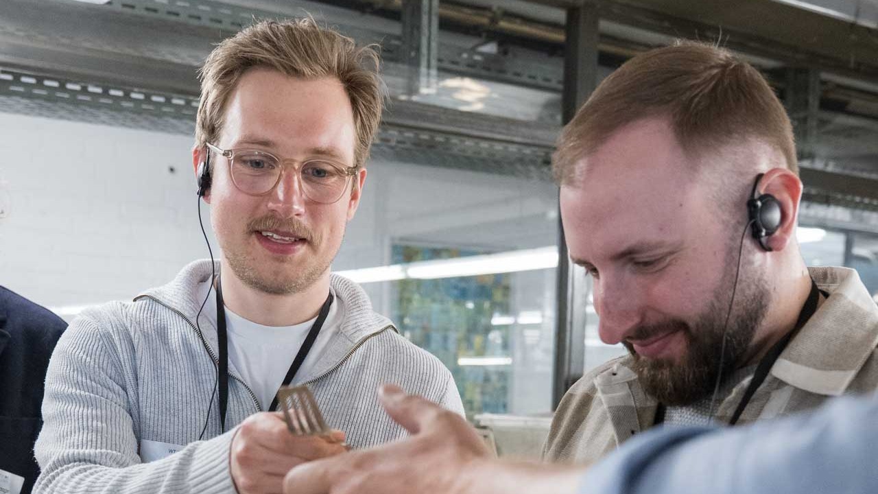 Zwei Männer schauen sich eine Silbergabel an